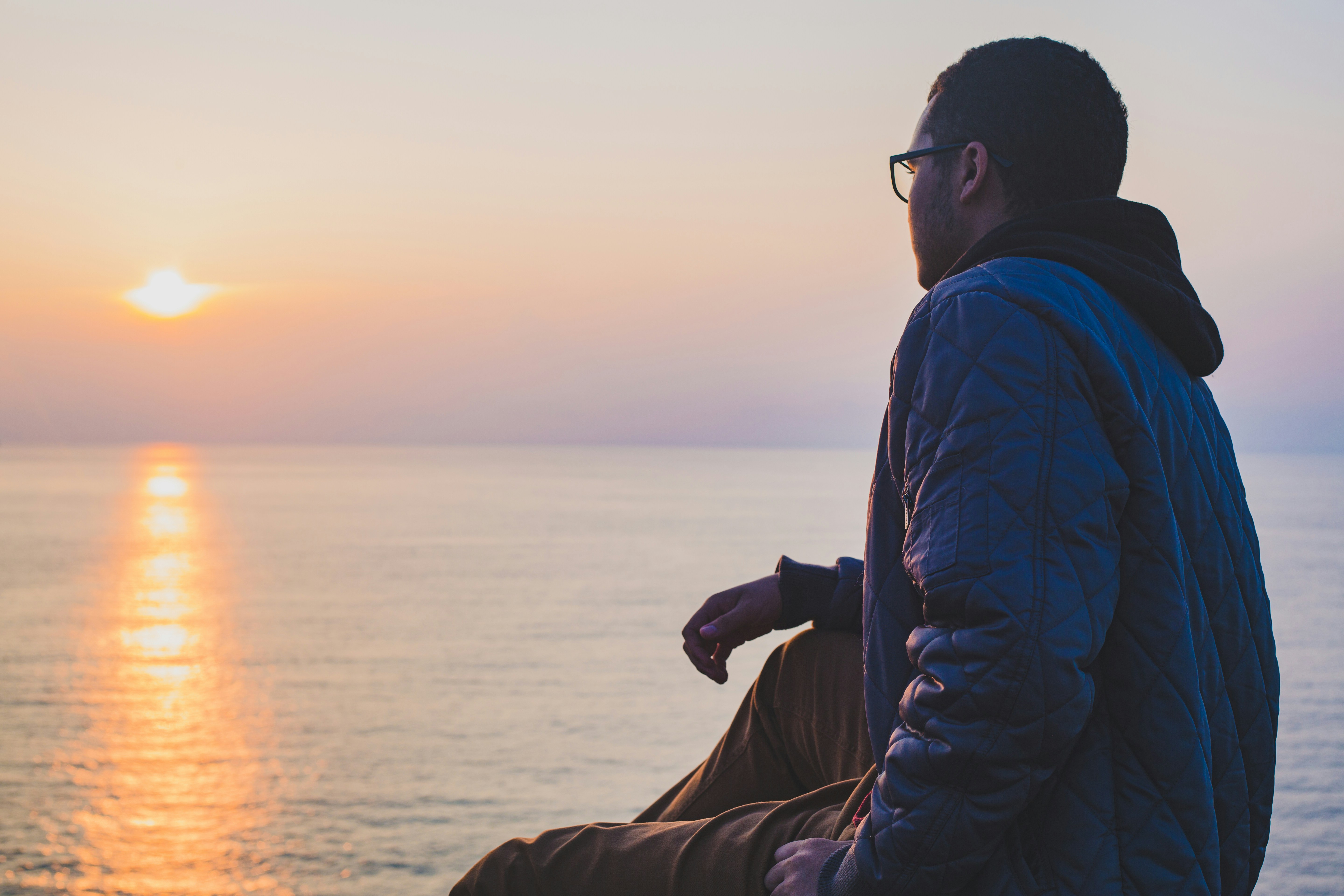 Person overlooking the water at sunset